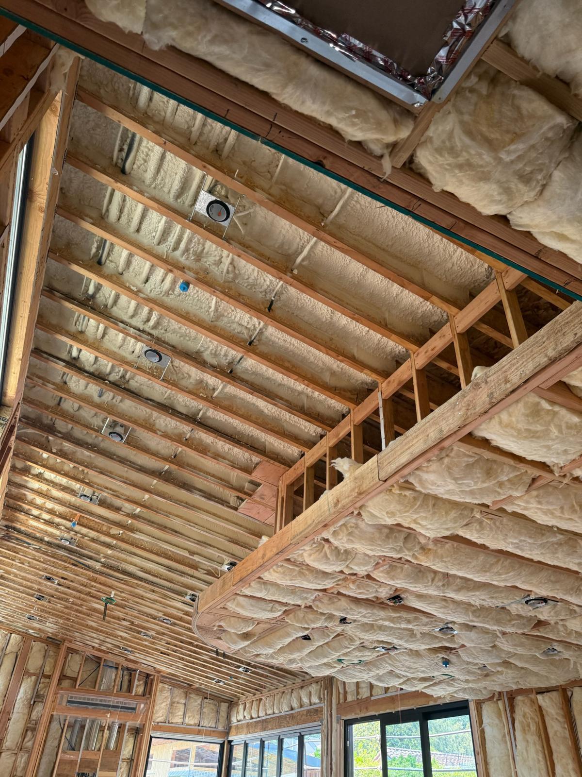 Spray foam and batt insulation installed across the framing of a new construction home
